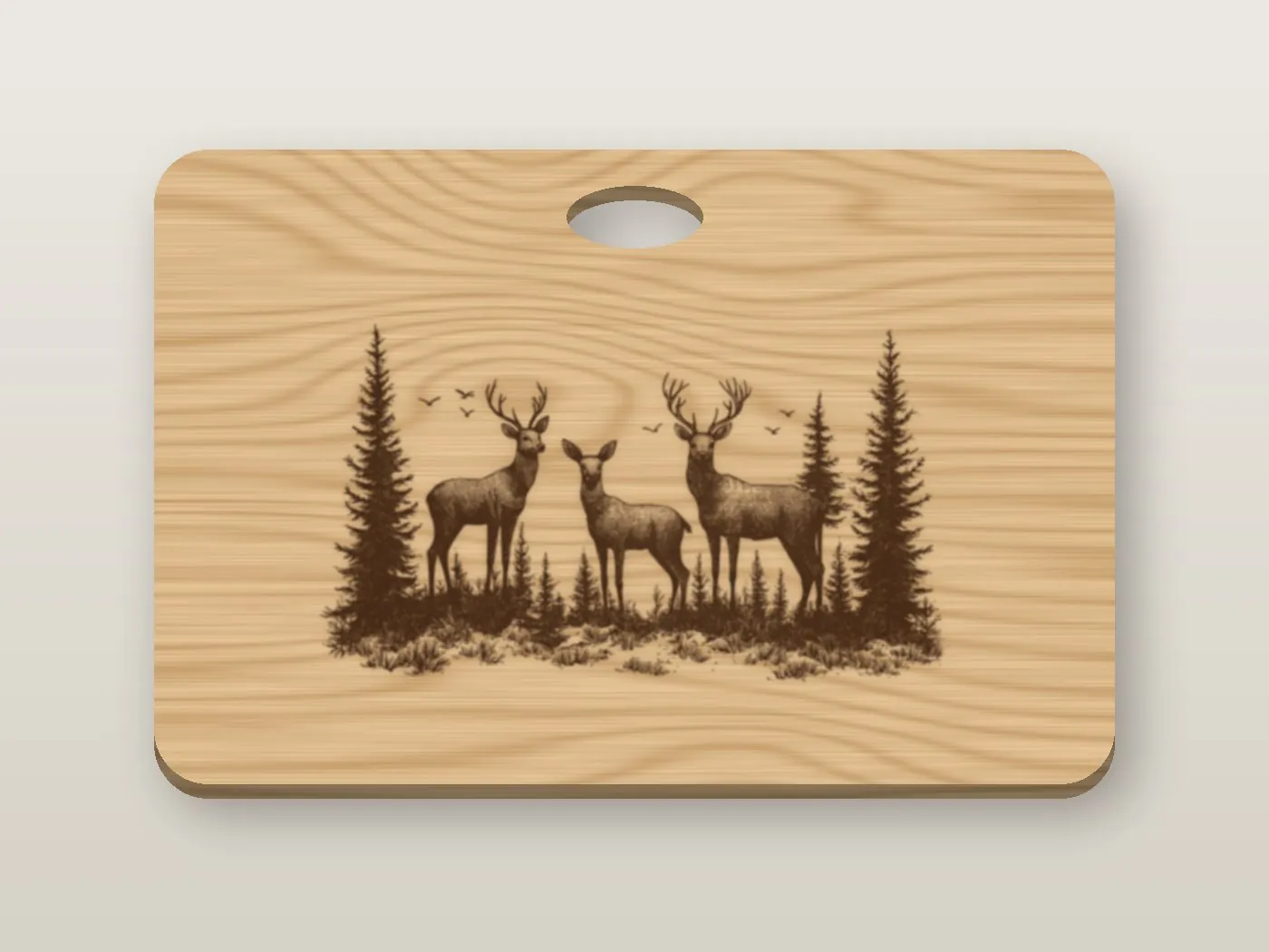 A maple cutting board engraved with three deer among pine trees